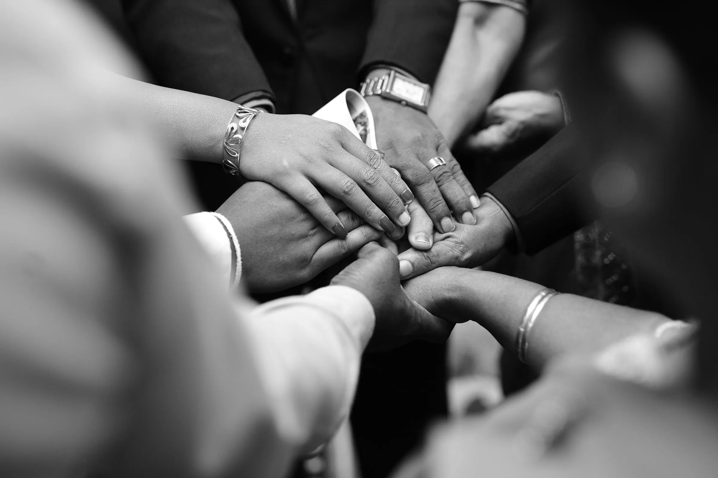 Many hands stacked together in a circle