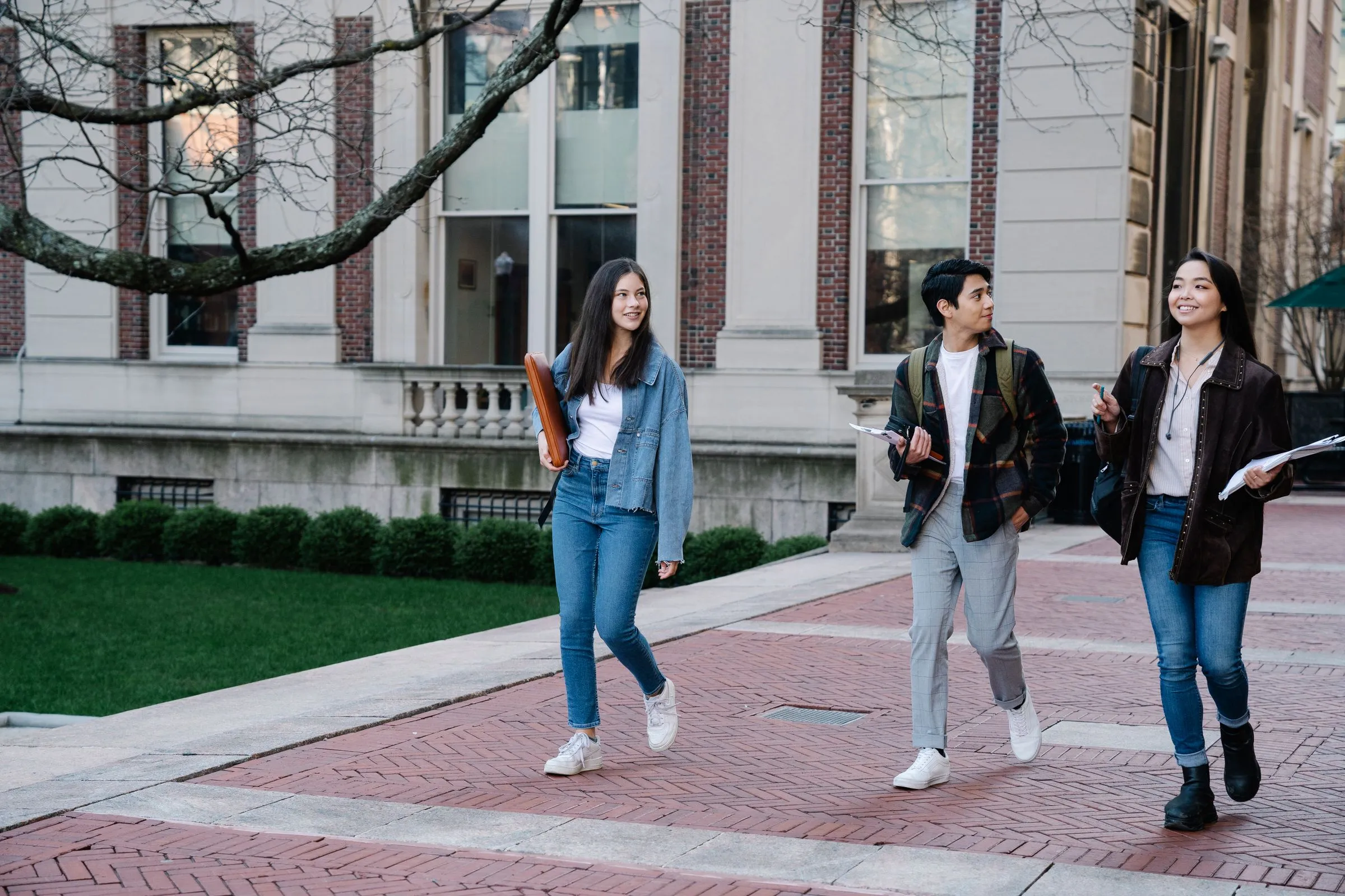 Three students walking together across a university campus