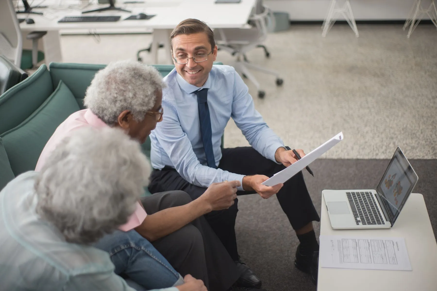 An adviser going through a document with two clients