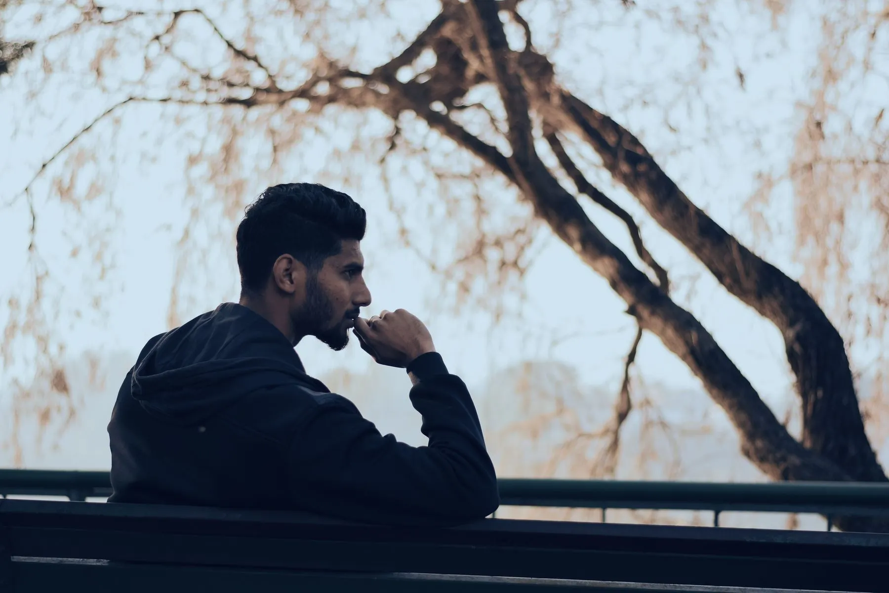 A person sitting outdoors, thinking